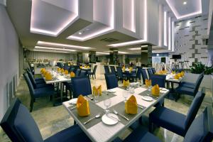 une salle à manger avec des tables et des chaises bleues dans l'établissement Tjokro Hotel Pekanbaru, à Pekanbaru