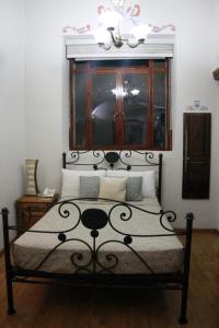 1 dormitorio con cama negra y ventana en Casa de los Dulces Sueños en Morelia