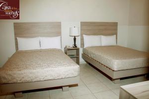 a hotel room with two beds and a night stand at Casa de los Dulces Sueños in Morelia