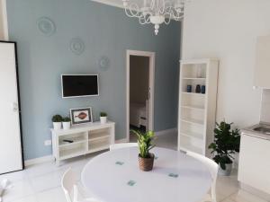 a living room with a white table and a tv at Casa Palma in Paestum