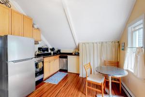 eine Küche mit einem weißen Kühlschrank und einem Tisch in der Unterkunft Historic Jewel in Provincetown