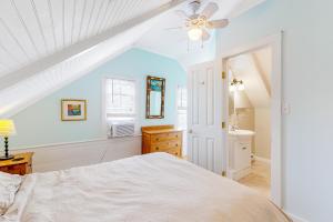 Schlafzimmer mit einem weißen Bett und einem Deckenventilator in der Unterkunft Historic Jewel in Provincetown