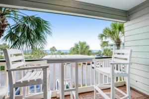 a porch with chairs and a table and a view of the ocean at Seacabin Villa 230-B in Isle of Palms