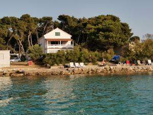a house sitting on the shore of the water at Apartment with sea viev - 20 m from sea in Ugljan