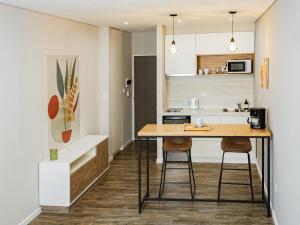 a kitchen with a wooden table and two stools at LEVEL Suites una propuesta diferente en el centro de Bahía in Bahía Blanca