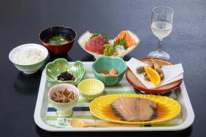 a tray of food on a table with bowls of food at Tabist Hotel Takagiya Iwaki in Hisanohama