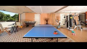 a gym with a ping pong table in a room at Vip Luxury Villa Privilege Classic in Gouvia