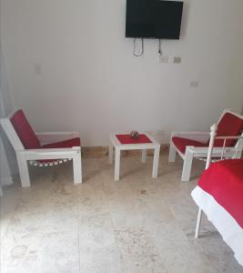 a room with two chairs and a tv and a table at Room in Guest room - Mono-local apartment type private garden Boca Chica resort in Boca Chica