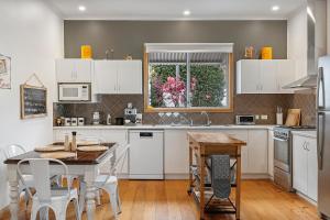 a kitchen with white cabinets and a table and chairs at Jack's House 2 B&B in Mill Street in Clare