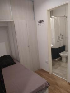 a bedroom with a bed and a bathroom with a toilet at Aires Verdes Salta in Salta
