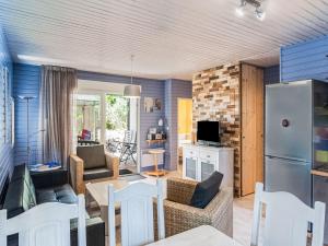 een woonkamer met een bank en een keuken met een koelkast bij Lavender holiday home with private terrace in Grimaud