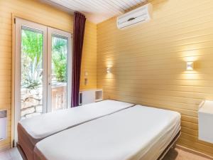 een slaapkamer met een bed en een raam bij Lavender holiday home with private terrace in Grimaud