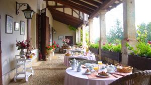 un patio al aire libre con mesas con comida. en Le Chatenet 1689, en Brantôme