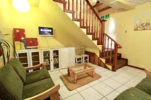 a living room with a couch and a staircase at La Casa Cuencana in Cuenca