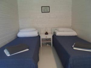two twin beds in a small room with a table at Tihase puhkemajake in Pärnu