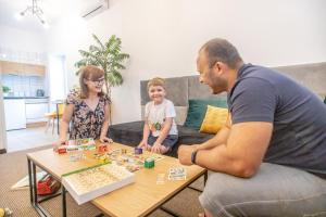 a man and a woman playing a board game with a child at Miodowa Zagroda - nocleg Zator Energylandia in Miejsce