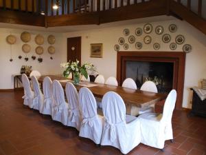 una mesa grande y sillas en una habitación con chimenea en Belvilla by OYO Villa del Lago, en Sanfatucchio
