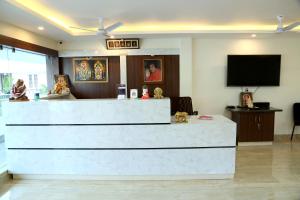 a lobby with a reception desk and a flat screen tv at THAAI RESIDENCY in Tiruvannāmalai