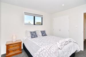 A bed or beds in a room at Lavandula 3 - Christchurch Holiday Homes