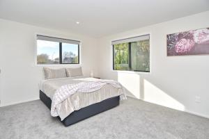 A bed or beds in a room at Lavandula 3 - Christchurch Holiday Homes