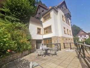 a building with a table and chairs in front of it at Villa Sonnenblick in Kurort Rathen