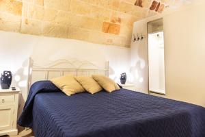 sypialnia z niebieskim łóżkiem i dwiema poduszkami w obiekcie B&B Nel Blu Dipinto Di Blu w mieście Polignano a Mare