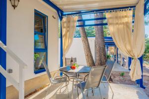 d'une terrasse avec une table, des chaises et une fenêtre. dans l'établissement Port 9 Mobile Homes by Aminess, à Korčula