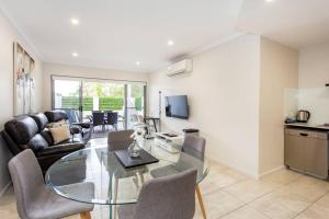 a living room with a glass table and chairs at Parkland View Sanctuary - EXECUTIVE ESCAPES in Perth