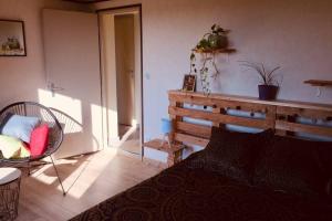 - une chambre avec un lit et une chaise dans l'établissement Appartement avec vue sur les vignes à Gevrey, à Gevrey-Chambertin