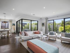 a living room with white furniture and large windows at Mannagum Mt Duneed 59 in Mount Duneed