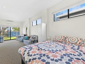 a bedroom with a king sized bed and a living room at Inveray Beach House 11 in Torquay