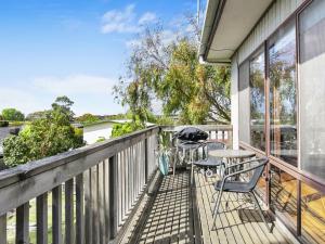 a patio with a table and chairs on a balcony at Inveray Beach House 11 in Torquay