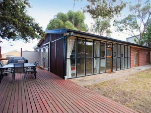 a house with a deck with a table on it at Great Ocean Retreat 43 in Torquay