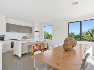 a kitchen and dining room with a wooden table and chairs at Coast Drive Beach and Golf 31 in Torquay