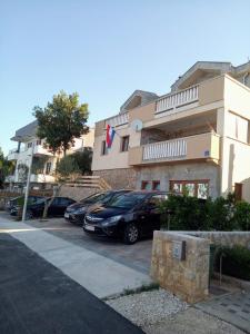 a building with cars parked in a parking lot at Apartment Andjela in Starigrad