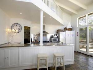 a kitchen with a counter with stools and a clock at Barnett Place 6 in Torquay