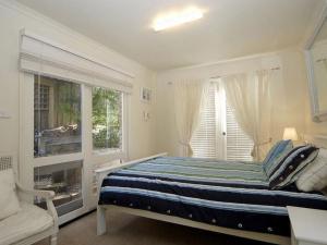 a bedroom with a bed and a window and a couch at Barnett Place 6 in Torquay