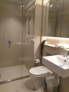 y baño con ducha, aseo y lavamanos. en Orange Stay at Collins Wharf, en Melbourne
