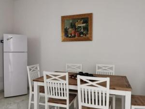 une cuisine avec une table, des chaises et un réfrigérateur dans l'établissement Paolanna Rooms Affittacamere, à Syracuse