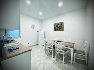 une cuisine avec une table, des chaises et un réfrigérateur dans l'établissement Paolanna Rooms Affittacamere, à Syracuse