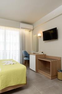 パラリア・カテリニスにあるRegina Mare Hotelのベッド1台、薄型テレビが備わるホテルルームです。