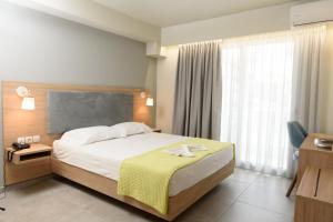 a hotel room with a bed and a large window at Regina Mare Hotel in Paralia Katerinis
