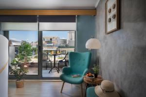a living room with a blue chair and a balcony at Nidus Villa in Souda