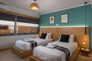 2 camas en una habitación con paredes azules en Nidus Villa, en Suda