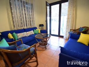 a living room with a blue couch and chairs at Summer Colours Home by RentalsPro- Kallithea Halkidiki in Kallithea Halkidikis