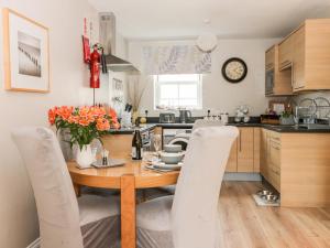 a kitchen with a wooden table and chairs in a kitchen at Nett's Coastal Escape in Filey