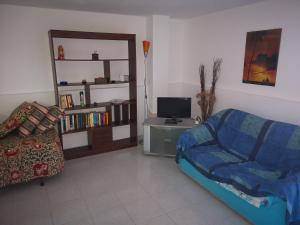 a living room with a couch and a tv at Casa Adriana in Alghero