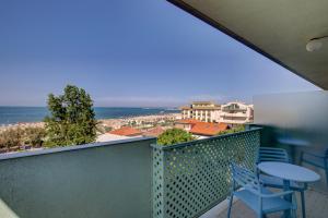 einen Balkon mit einem Tisch, Stühlen und Meerblick in der Unterkunft Hotel Ivano in Rimini