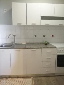 kuchnia z białymi szafkami i zlewem w obiekcie Apartment Vera, 80 m from the sea w mieście Novigrad