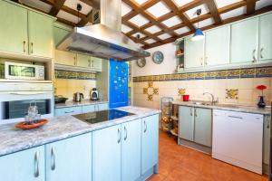 uma grande cozinha com armários brancos e paredes azuis em Villa La bicicleta azul em Málaga